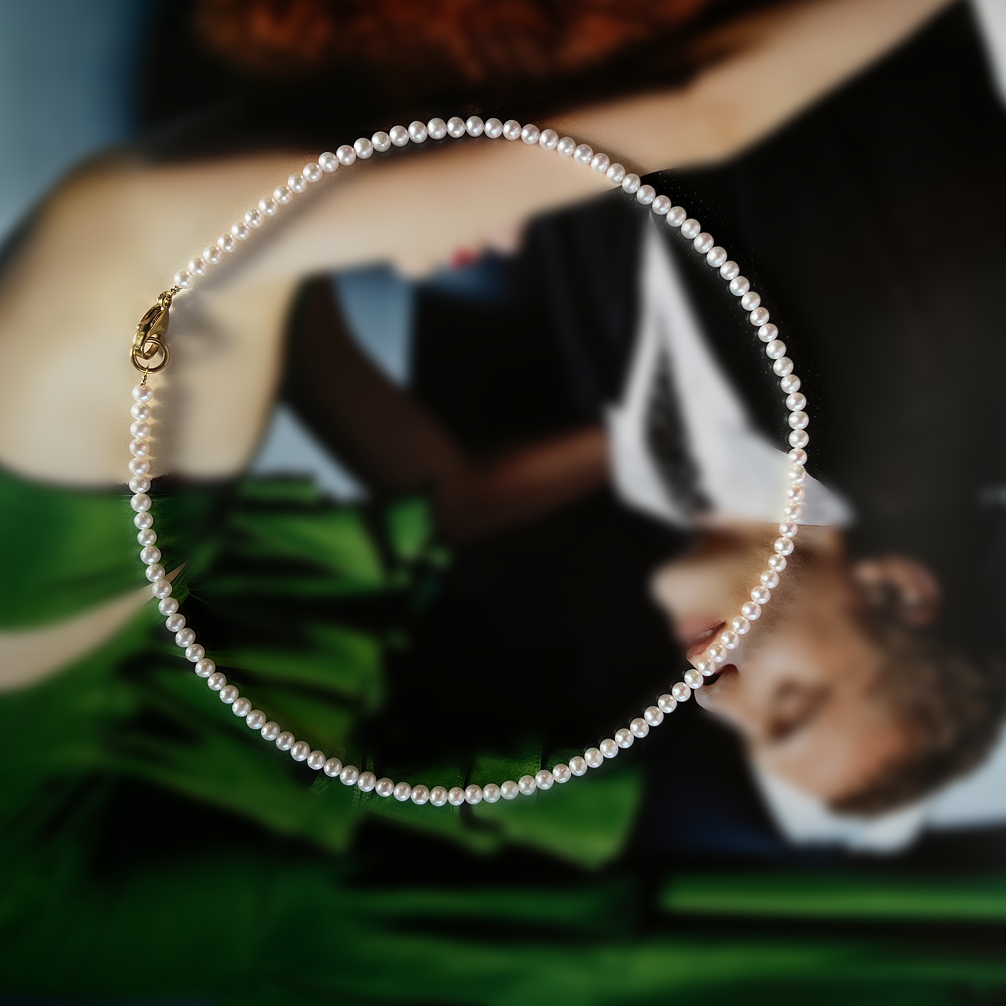 Collar de perlas pequeñas con broche dorado ROKA sobre fondo artístico desenfocado, joyería de acero inoxidable.